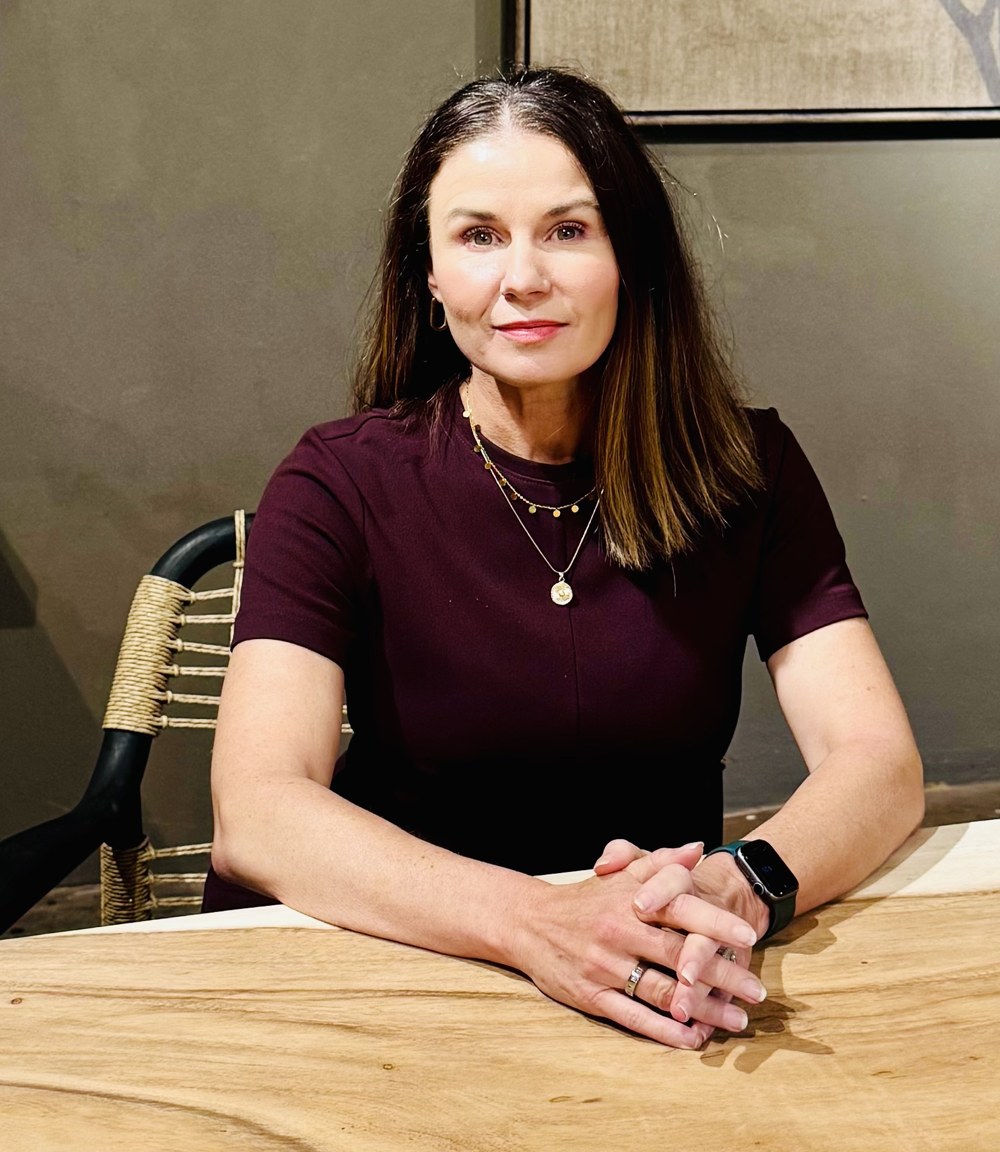 Lindi seated at a wooden table
